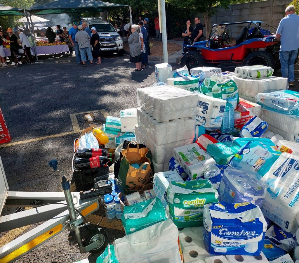 Members of The Wild Buggers Beach Buggy Club unloading a trailer full of charity donations for the Huis Uitsig old age home.