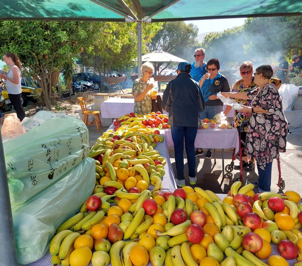 Heavily laden tables featuring fresh fruit platters and healthy snacks arranged by The Wild Buggers Beach Buggy Club members.