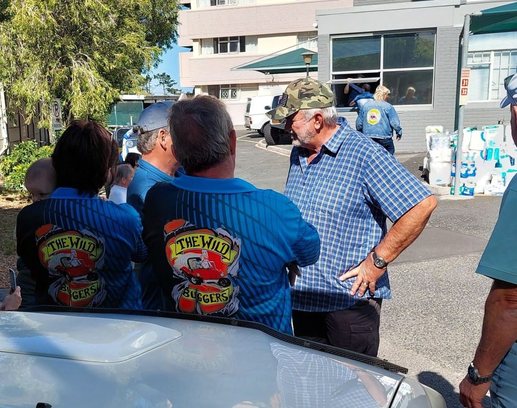 Members of The Wild Buggers Beach Buggy Club chatting with senior citizens during a community visit.