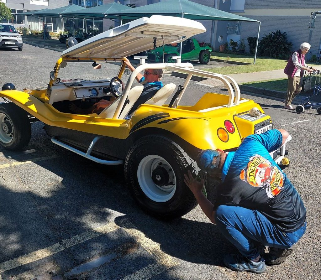 Rhoodie inspecting the VW air-cooled engine of Chris's beach buggy to ensure it's in top condition during the club event.