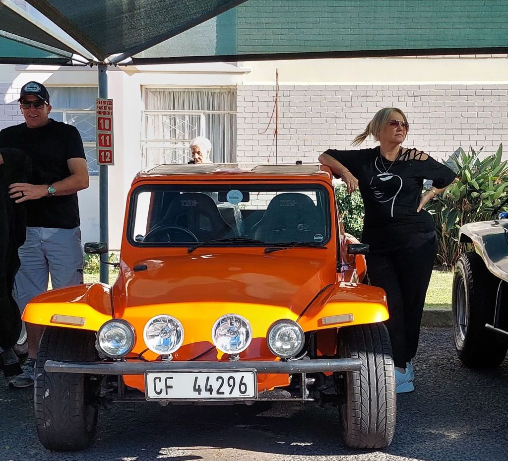 Brent and Sam van der Weijde standing with their orange Salamander Beach Buggy, "The Wasp," at Huis Uitsig during the charity run.