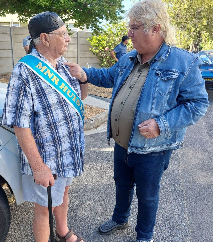 Wild Buggers member Hannes presenting his club cap to "Mr. Huis Uitsig" during the charity event.