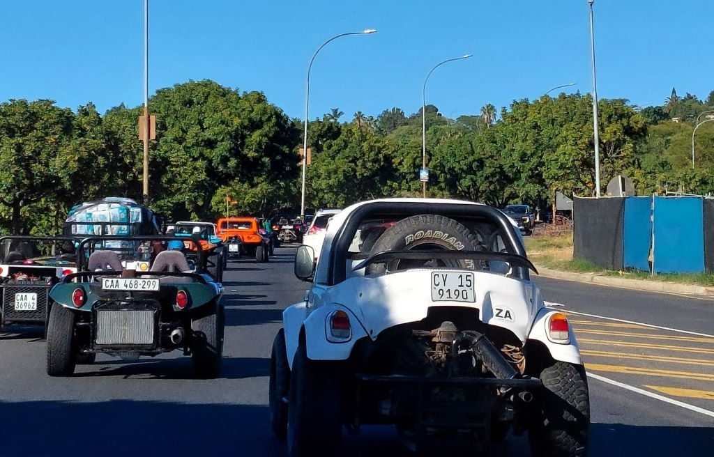 A colorful convoy of Wild Buggers Beach Buggies and old school VW air-cooled vehicles cruising on the road to Huis Uitsig.
