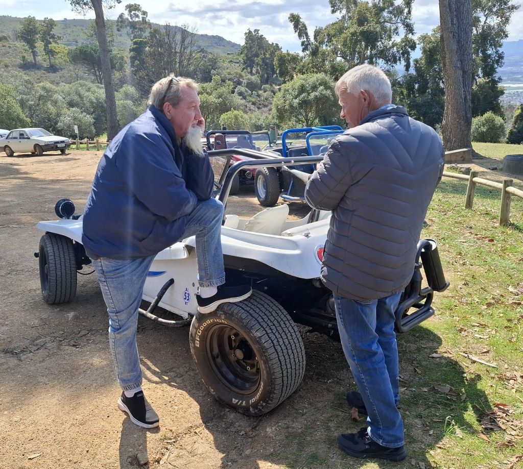 Chris Zara and Willie Koekemoer discussing Nick Mitchell's white Beamish beach buggy with a VW air-cooled Beetle motor.