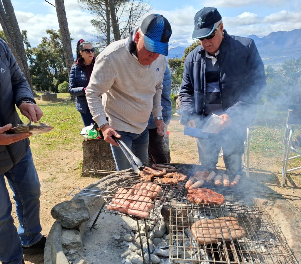 Mario, Theo, and Willie standing by the braai at a Wild Buggers Beach Buggy Club event.