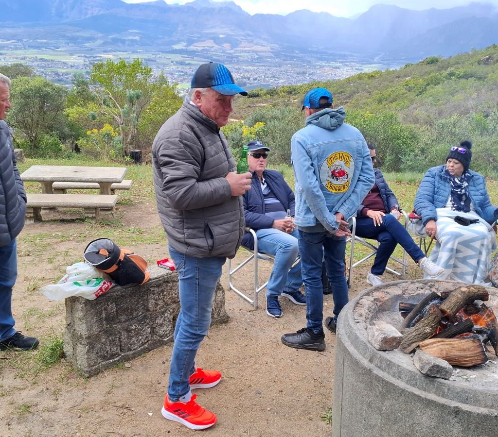 Wild Buggers Beach Buggy Club members gathered and chatting around the braai area during a club event.