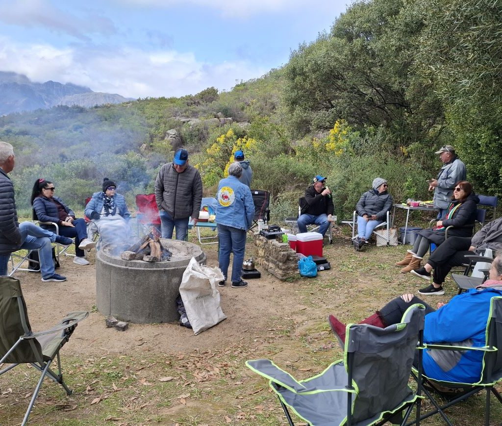 Wild Buggers Beach Buggy Club members chatting and relaxing by the braai during a club event.