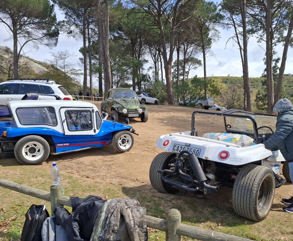 Nick and Ellie’s white Beamish, Jess’s blue Kestrel, and Mickey’s green Baja Bug parked in the parking area during a Wild Buggers event.