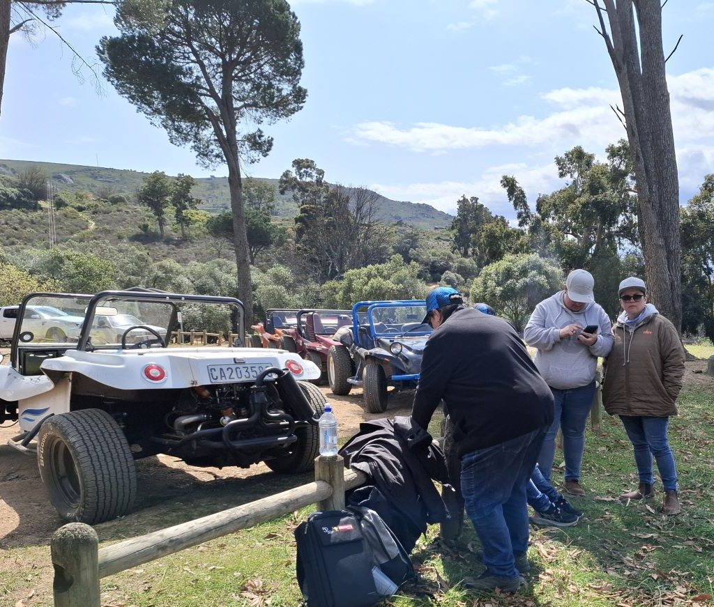 A few Wild Buggers beach buggies parked with a group of members standing nearby during a club event.