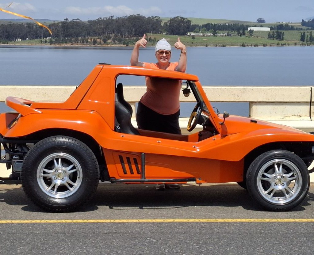 Sam giving a thumbs-up at their orange Salamander beach buggy during the Wild Buggers Winelands Breakfast Run.