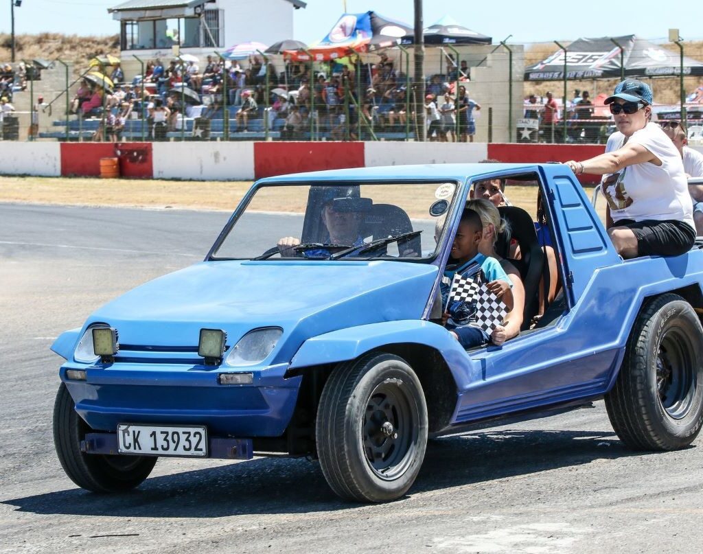 Rhoodie Ackerman driving his blue Kango beach buggy with a Nissan 1400 motor, carrying children around the track at the Wild Buggers Beach Buggy Club's Killarney International Raceway charity run.