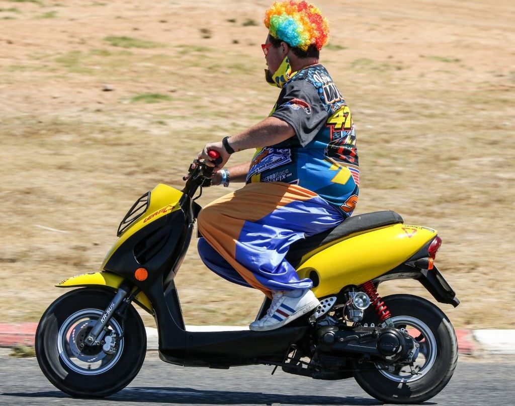 A clown on a scooter joins the Wild Buggers Beach Buggy Club on the track at their Killarney International Raceway charity run.