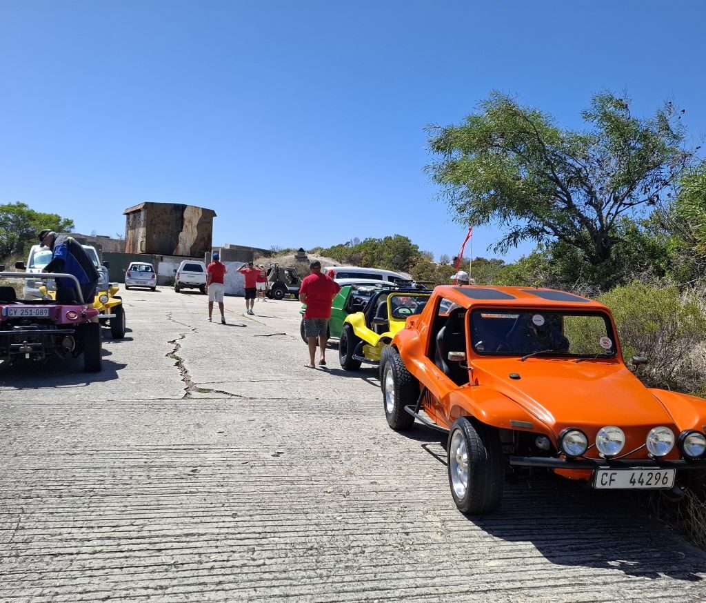 Beach buggies parked with The Cannon in the background during the Wild Buggers Beach Buggy Club's Valentine's Day run in Simon's Town. Classic VWs and a historic landmark.
