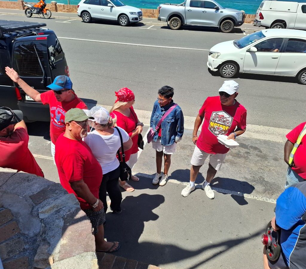 Wild Buggers Beach Buggy Club members having a quick chat outside Dixie's Restaurant, preparing to resume their Valentine's Day run. Classic VWs parked nearby.