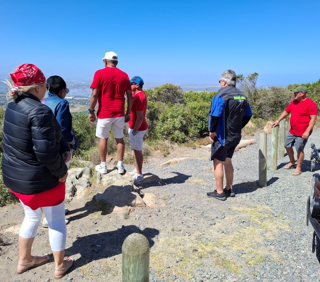 Wild Buggers Beach Buggy Club members enjoying a panoramic view from a scenic lookout point during their Valentine's Day run. Classic VWs parked nearby.