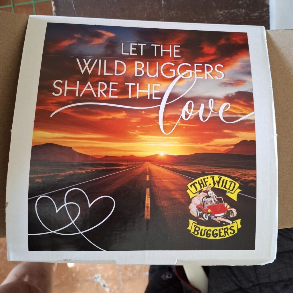 A handcrafted gift box, made and donated by Sam and Brent Van Der Weijde to Wild Buggers Beach Buggy Club members, is displayed during their Valentine's Day run. The box is filled with various items.