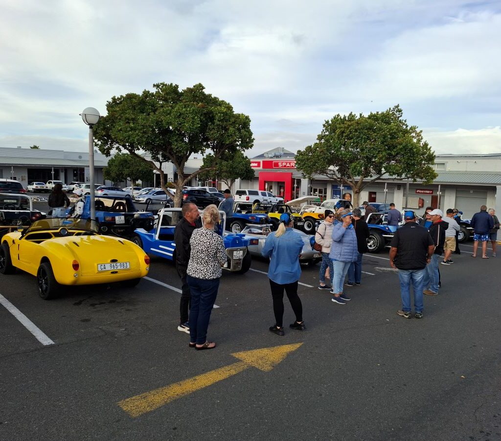 Wild Buggers Beach Buggy Club members chatting and catching up at the Reach for a Dream charity run, with beach buggies parked nearby.