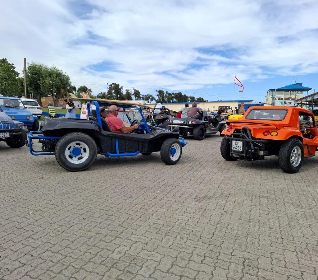 A photo of Wild Buggers beach buggies lined up at the Killarney International Raceway track, ready to take the Reach for a Dream children for another ride.