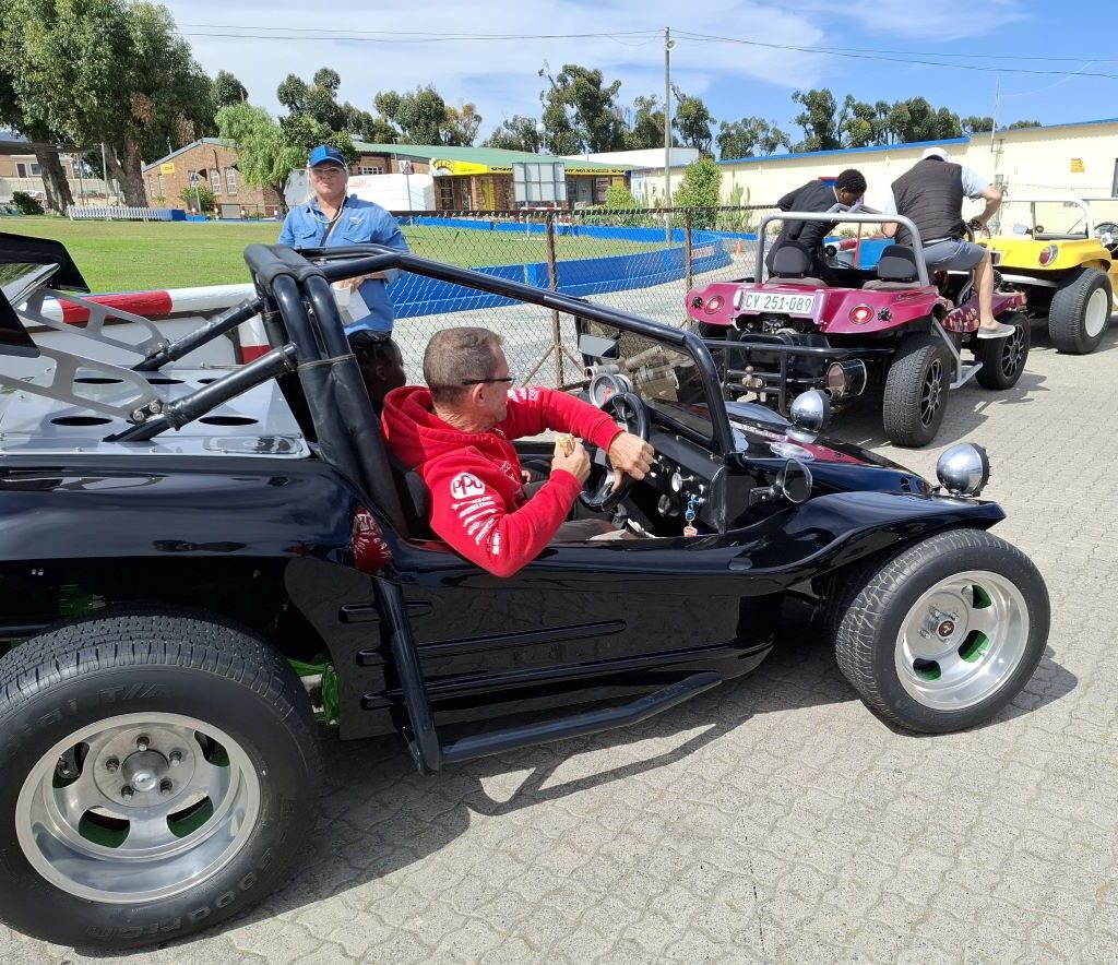A photo of Wild Buggers beach buggies lined up at the Killarney International Raceway track, ready to take the Reach for a Dream children for yet another ride.
