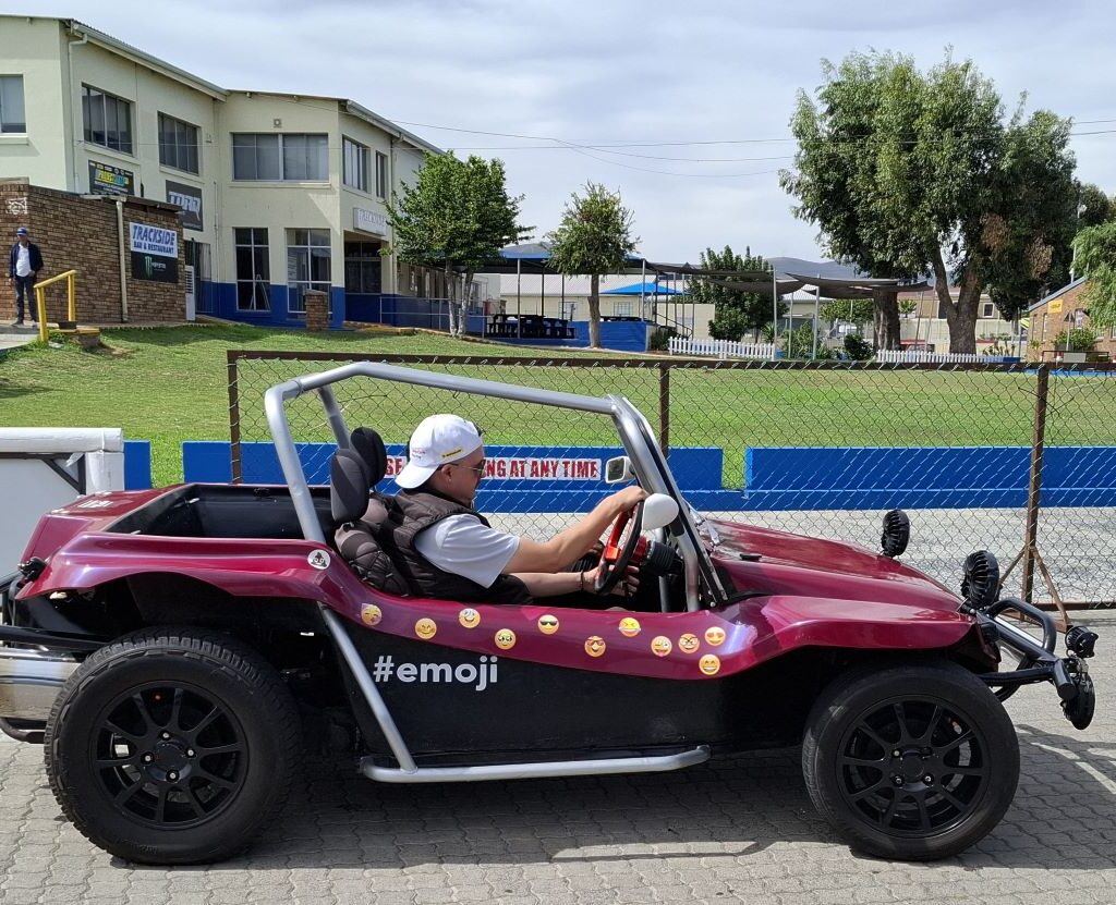 A photo of Gary Fleming's pink "Emoji 3" Beamish beach buggy at the Killarney International Raceway track, ready to take the Reach for a Dream children for a ride.