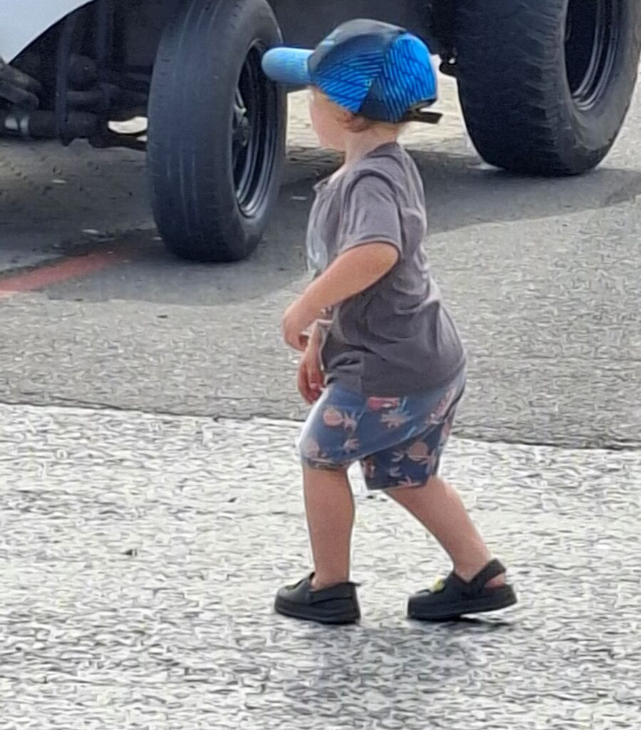 A photo of a young child wearing a Wild Buggers Beach Buggy Club cap, running with excitement at the Reach for a Dream charity run.