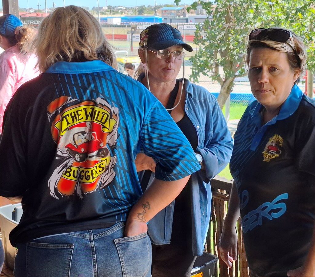 A photo of three women, likely Wild Buggers Beach Buggy Club members, appearing to be planning or organizing something at the Reach for a Dream charity run.