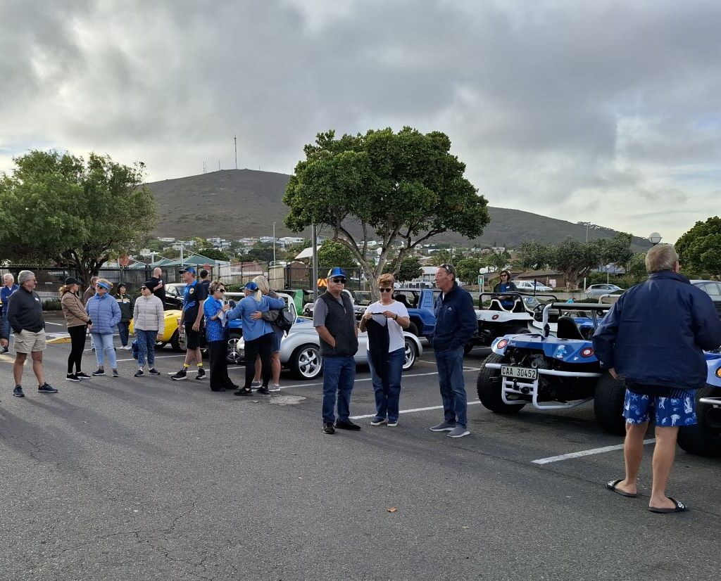 Wild Buggers Beach Buggy Club members happily greeting each other at the Reach for a Dream charity run, with beach buggies in the background.