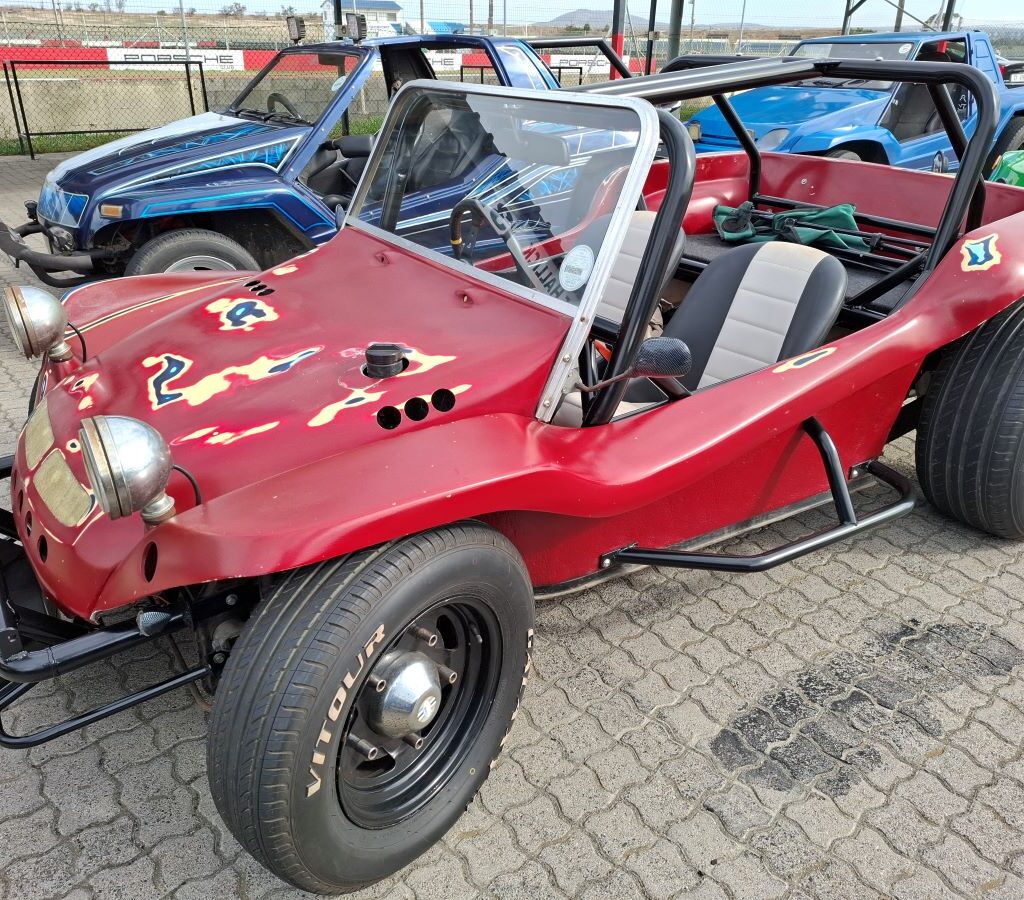 William's red Beamish beach buggy undergoing the finishing touches in a busy workshop setting during the Wild Buggers Reach for a Dream charity run preparations.