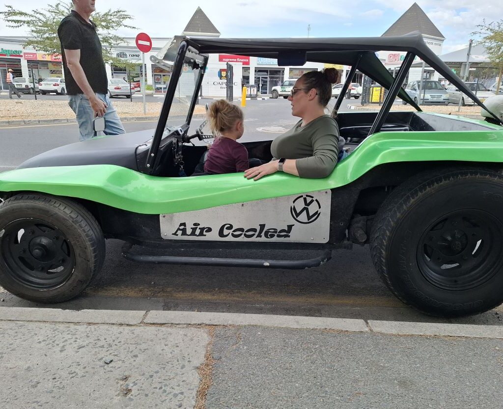 A vibrant green Beamish beach buggy, possibly a 1600 VW air-cooled, is shown in a scenic outdoor setting, highlighting its unique design and cheerful color.