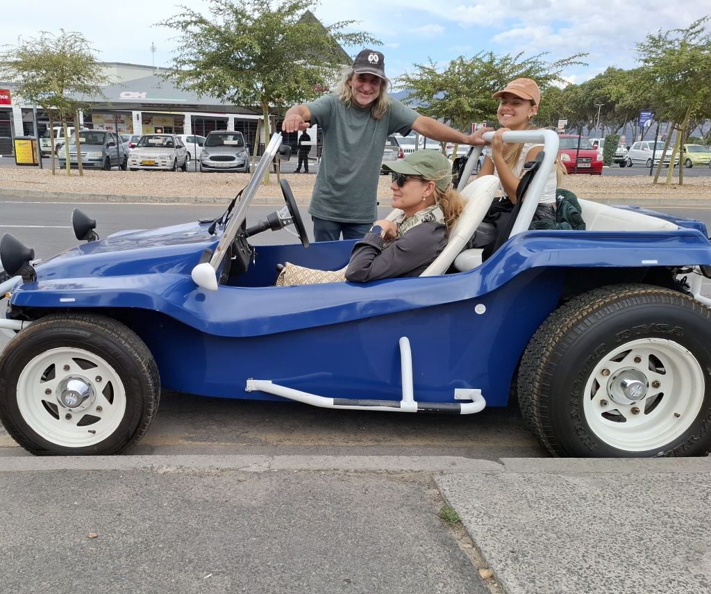 Craig is standing proudly next to his vibrant blue Beamish beach buggy, showcasing its design and condition, possibly during a stop on Wiehann's Run.