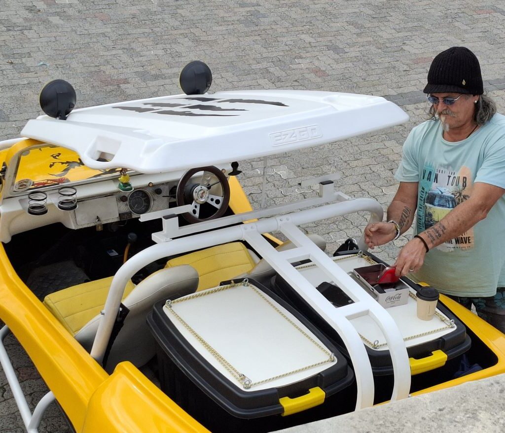 Tony uses the back seat of Chris's yellow 1600 VW air-cooled Salamander beach buggy as a makeshift table to sort out his medication during a stop on the Wild Buggers' Wiehann's Run.