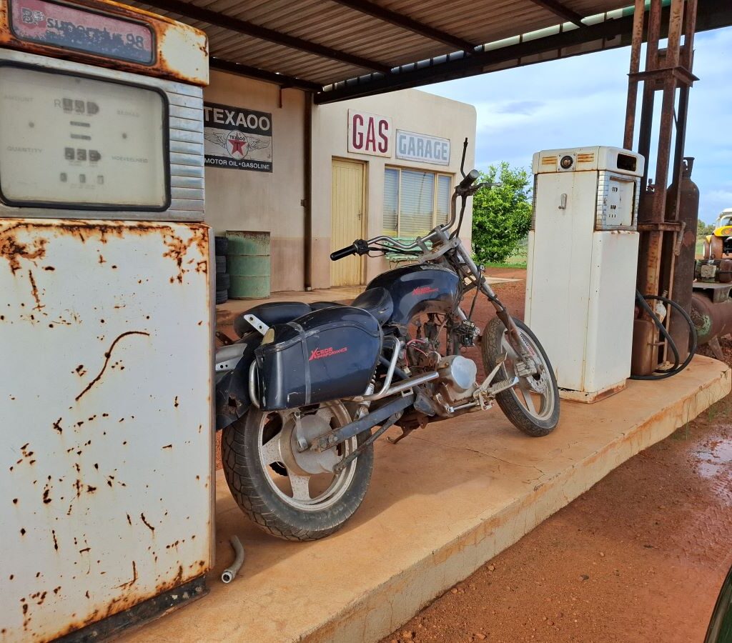 A very old, classic motorcycle parked at the secret gas station visited by The Wild Buggers Beach Buggy Club during Tony & Sue's Run.
