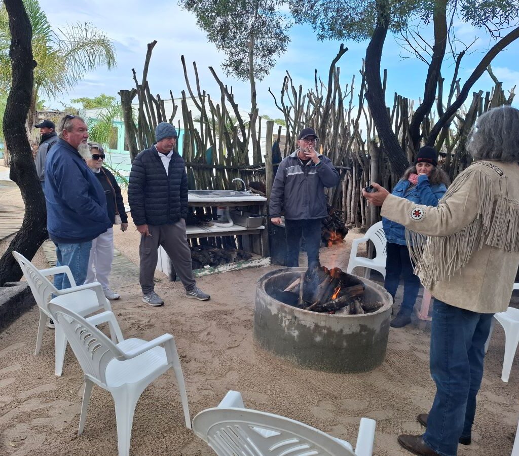 Wild Buggers club members gathered around a lit braai in the "Mauritius" setting, enjoying food and conversation during Tony & Sue's Run.