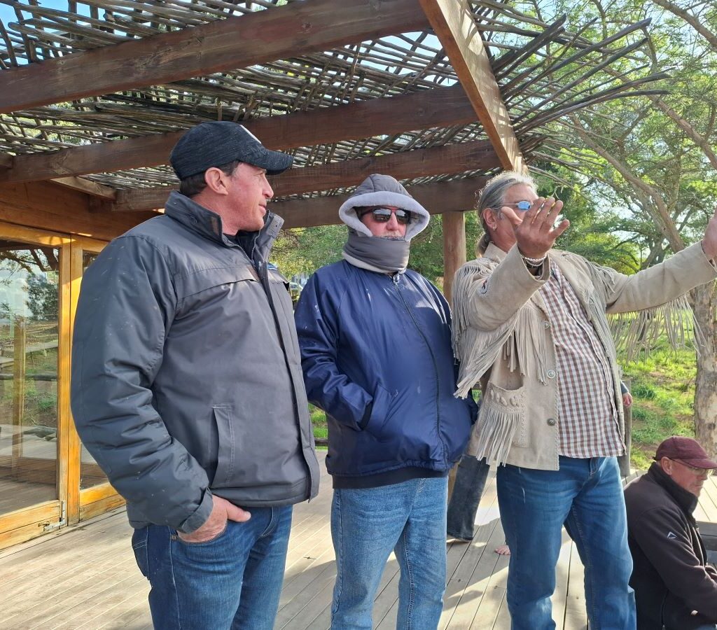 Tony pointing and showing Chris and Brent something interesting, likely a scenic view or unique detail, during The Wild Buggers' Tony & Sue's Run.