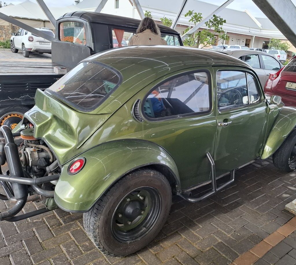 Mickey's green Baja Bug named 'The Dark Side', equipped with a VW air-cooled 1600 Beetle motor, parked in a lot during Tony & Sue's Run.