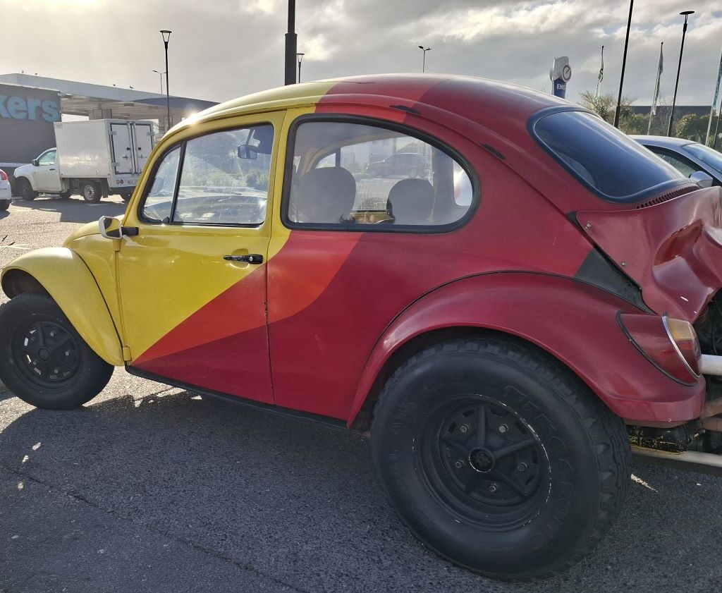 Yellow, red, and orange VW Air-Cooled Baja Bug at Wild Buggers 'Revving Up for the Lens' cruise