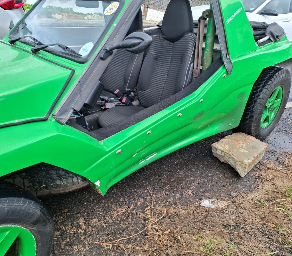 Green Kango beach buggy 'Shrek' with large rock as temporary handbrake on steep downhill at Wild Buggers 'Revving Up for the Lens' cruise