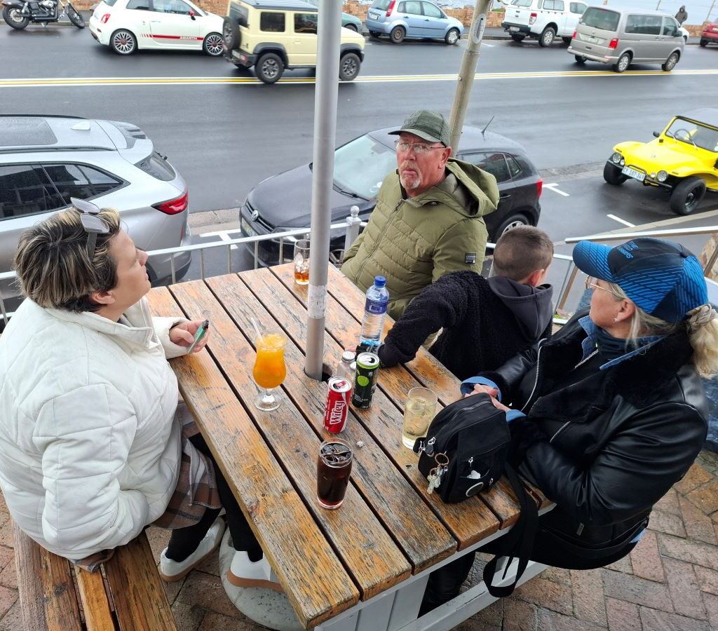 Wild Buggers chatting indoors with Anthony & Michelle's beach buggy parked in the rain outside at 'Revving Up for the Lens' event
