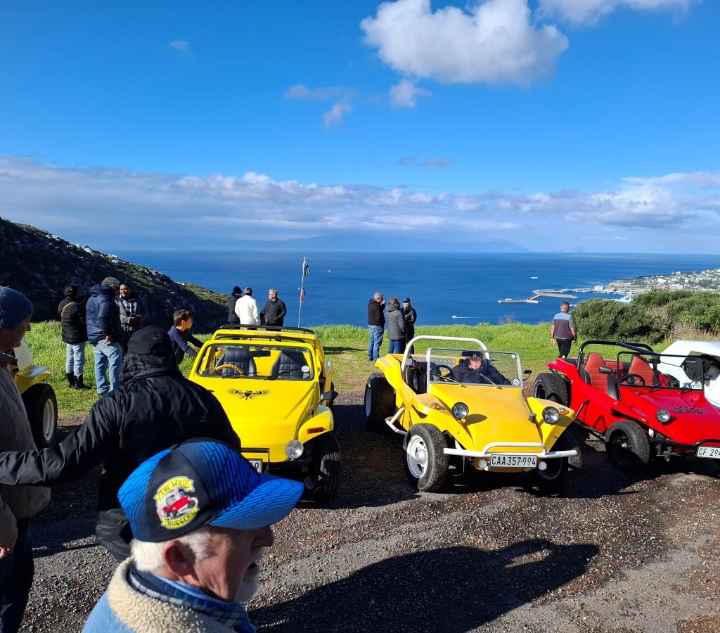 Wild Buggers members chatting and Cale interviewing on Red Hill with ocean background
