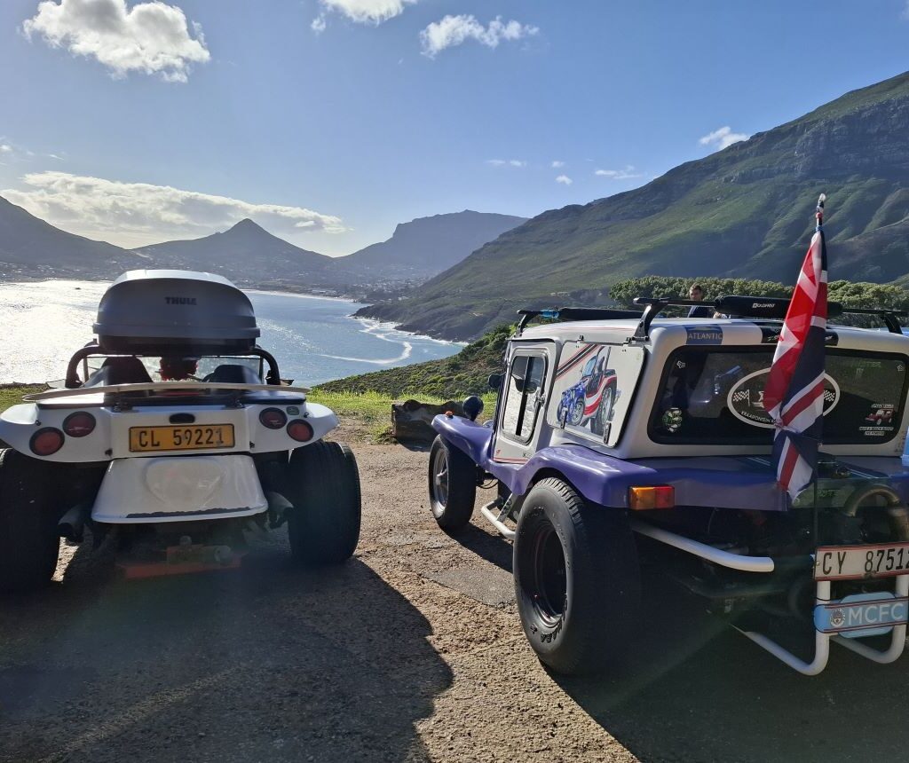 Nolan and Rory's beach buggies parked on Chapman's Peak with ocean and mountains in background