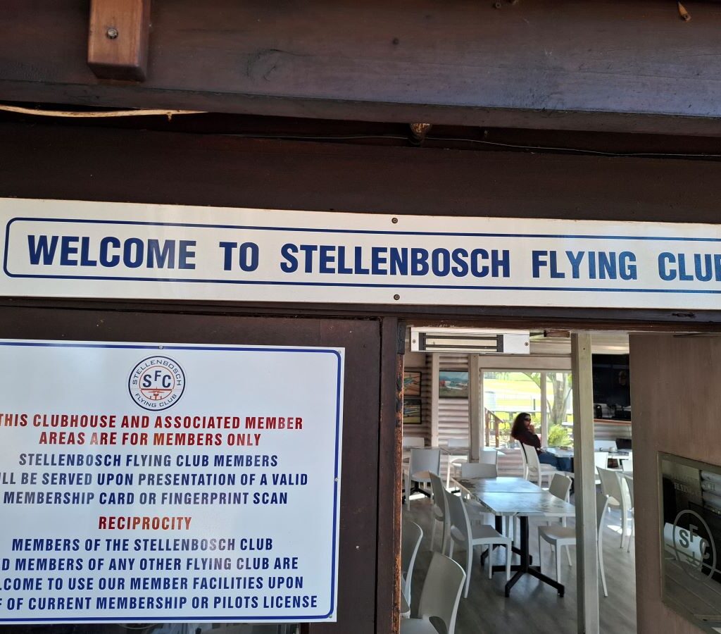 A photo of the official sign at the entrance to the Stellenbosch Flying Club, welcoming visitors, taken during the Wild Buggers' visit on Nick & Ellie's Run.