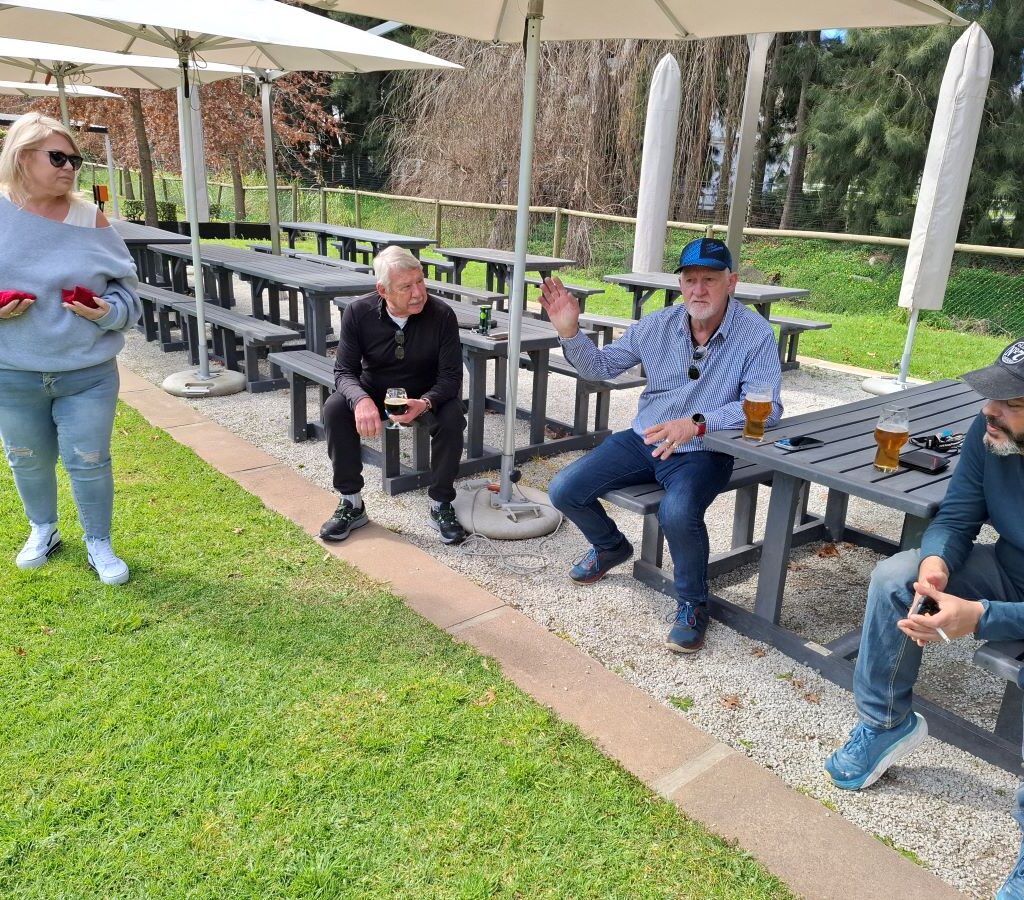 A photo of several Wild Buggers' club members sitting together, laughing and chatting in a relaxed setting during a break on their run.