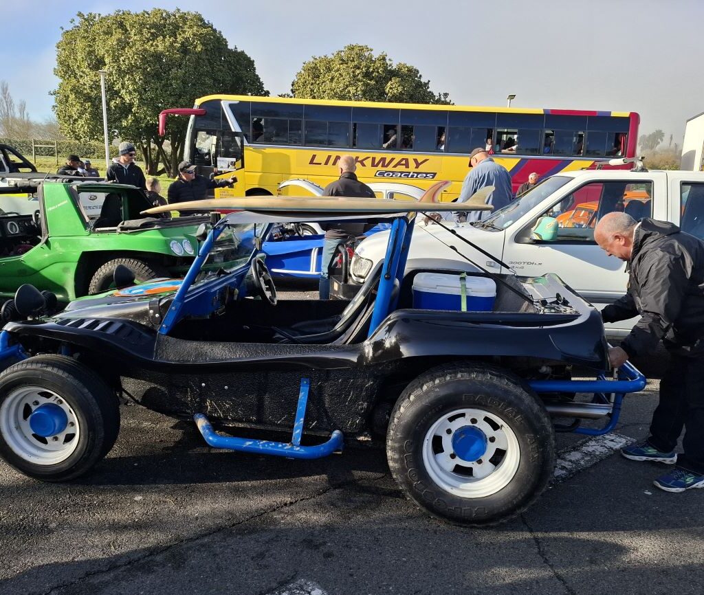 A photo of Wild Buggers Beach Buggy Club member Clive making final adjustments to his black Beamish beach buggy, named the Highway Surfer, which has a 1600 VW air-cooled Beetle motor, before the start of Nick & Ellie's Run.