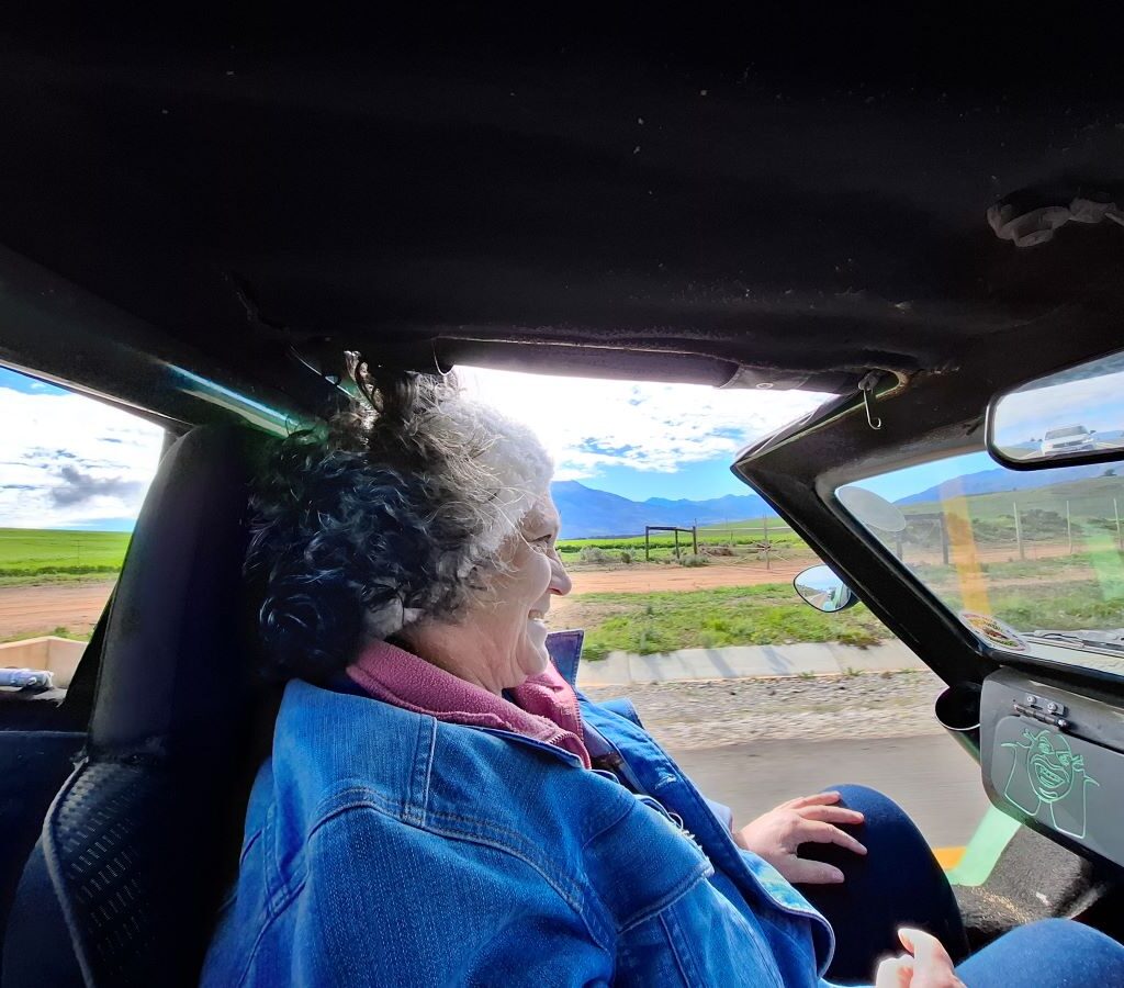 A photo of Mickey, the copilot, sitting in the passenger seat of a classic VW vehicle on a Wild Buggers club run, looking relaxed and enjoying the drive.