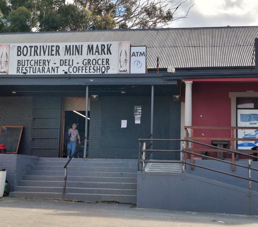 A photo of the entrance to the Botrivier Mini Market, a small market with a welcoming signboard, where the Wild Buggers Beach Buggy Club made a stop.