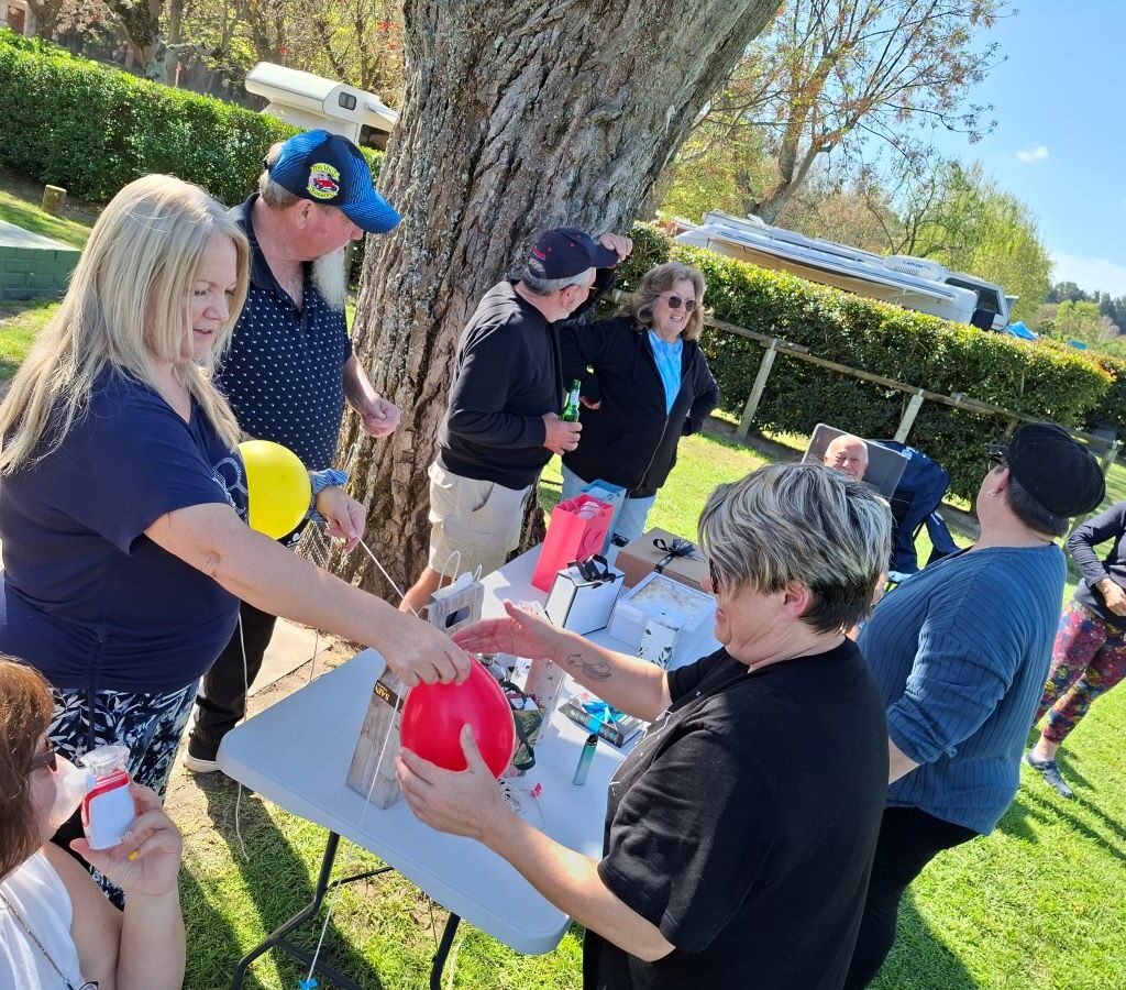 A funny photo of the Wild Buggers "Ladybugs" (Sandra, Sam, Michelle, Mickey, Yolande, and Linda) frantically blowing up even more balloons, demonstrating their dedication to making the impromptu campsite game bigger and more hilarious at the Bergriver Resort camp.