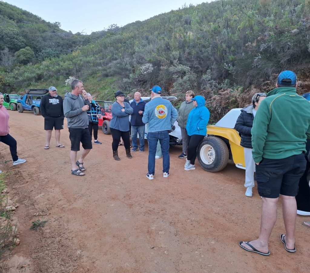 A wide, beautiful photo of the Wild Buggers members enjoying the final, extended moments of their sundowner on Paarlberg, taking in the scenic view and enjoying a last few laughs before heading their VW air-cooled vehicles back to the campsite.