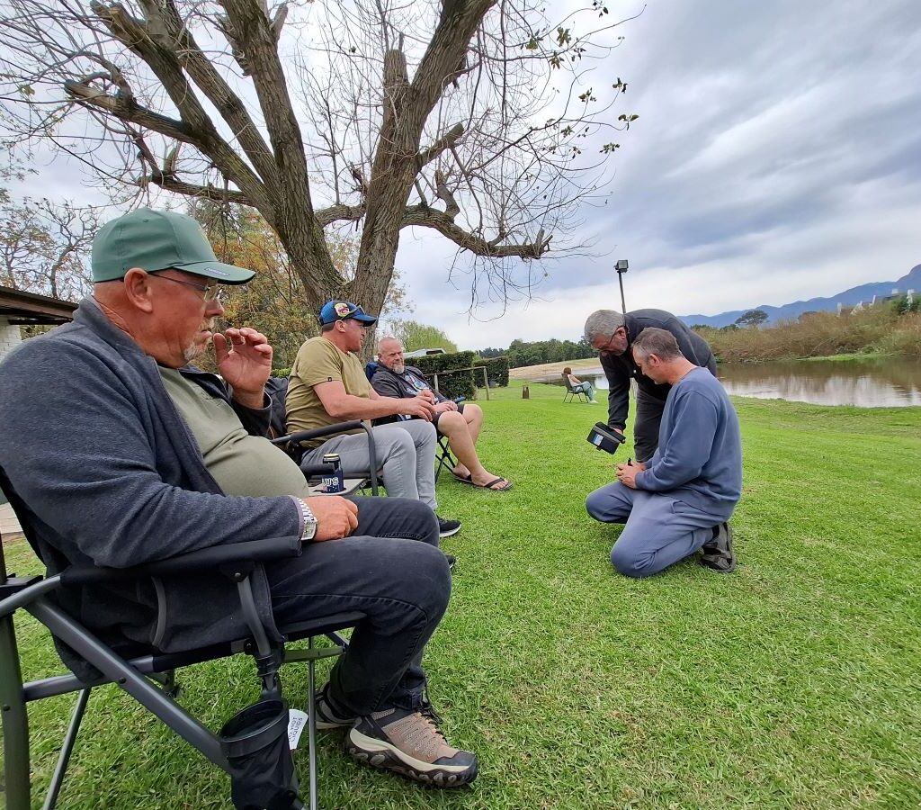 A final, peaceful photo of Wild Buggers members relaxing near the river at the Bergriver Resort camp, enjoying the last scenic views and a quiet chat before packing up their VW air-cooled vehicles.