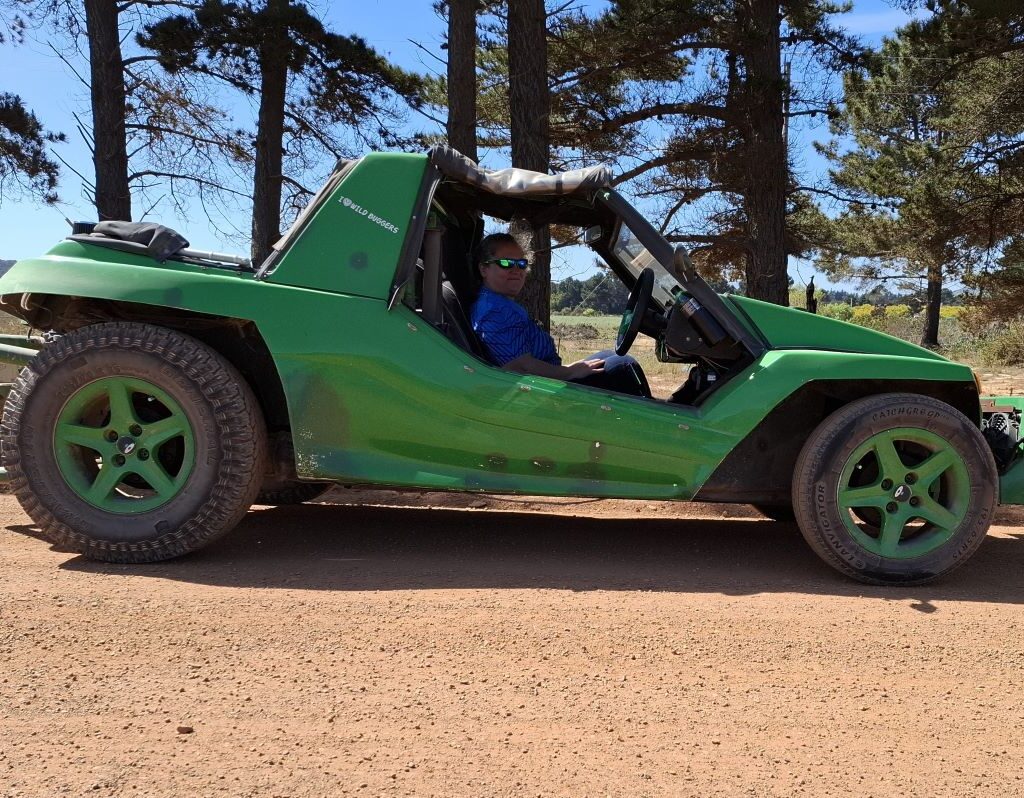 Mickey is pictured sitting in the club president's green Kango Beach Buggy, 'Shrek,' which is powered by a 1400 Nissan motor, during a roadside pitstop.