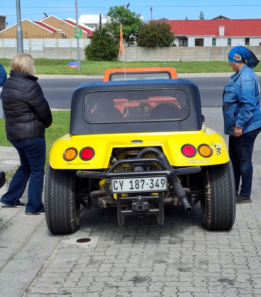 Sam and Mickey check on Michelle, who is sitting in her VW Beach Buggy, Bumble Bee, at a roadside stop.